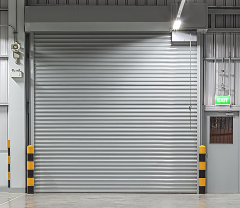 Closed industrial roller shutter at a commercial unit at night